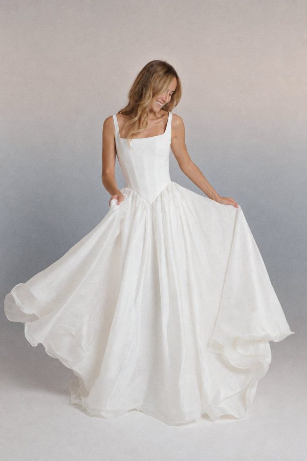 Tirol wedding dress by Rara Avis with fine straps, a square neckline and a flowing ivory skirt